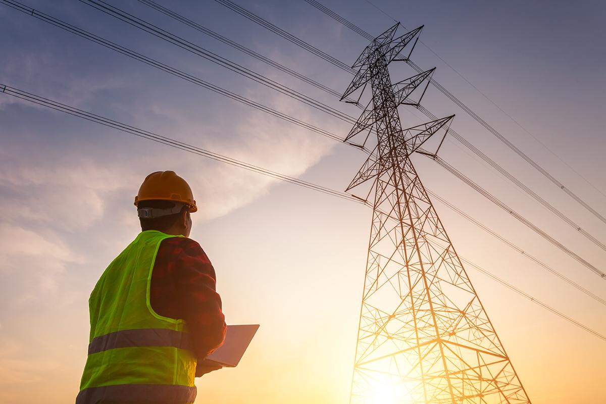 A safety engineering manager working with CMMS ERP TAG The Asset Guardian inspection high-voltage electricity pole.